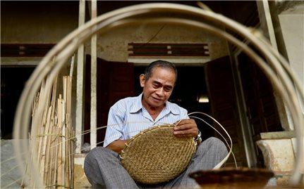 Ông Đinh Văn Xếp với sản phẩm mây tre đan của người Hrê