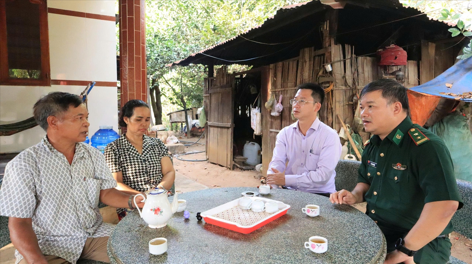 Già làng Điểu Ngon (bên phải) trò chuyện với cán bộ Bộ đội Biên phòng thành phố Đồng Nai và lãnh đạo địa phương đến thăm