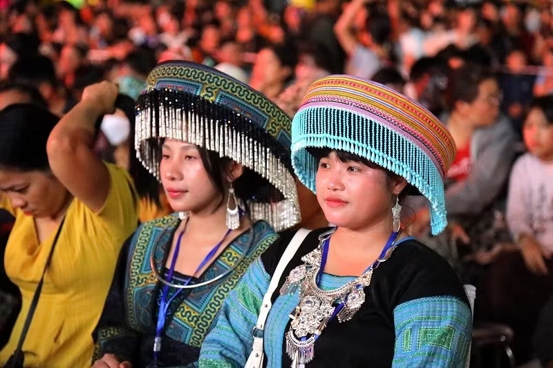 Các cô gái dân tộc Mông chăm chú theo dõi lễ khai mạc Ngày hội. (Ảnh: LÊ LAN)