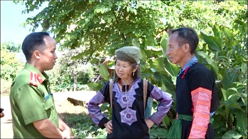 Già làng Sùng A Dếnh (bên phải) trao đổi với cán bộ Công an về công tác tuyên truyền, vận động đồng bào Mông chấp hành pháp luật, giữ gìn an ninh trật tự tại địa phương