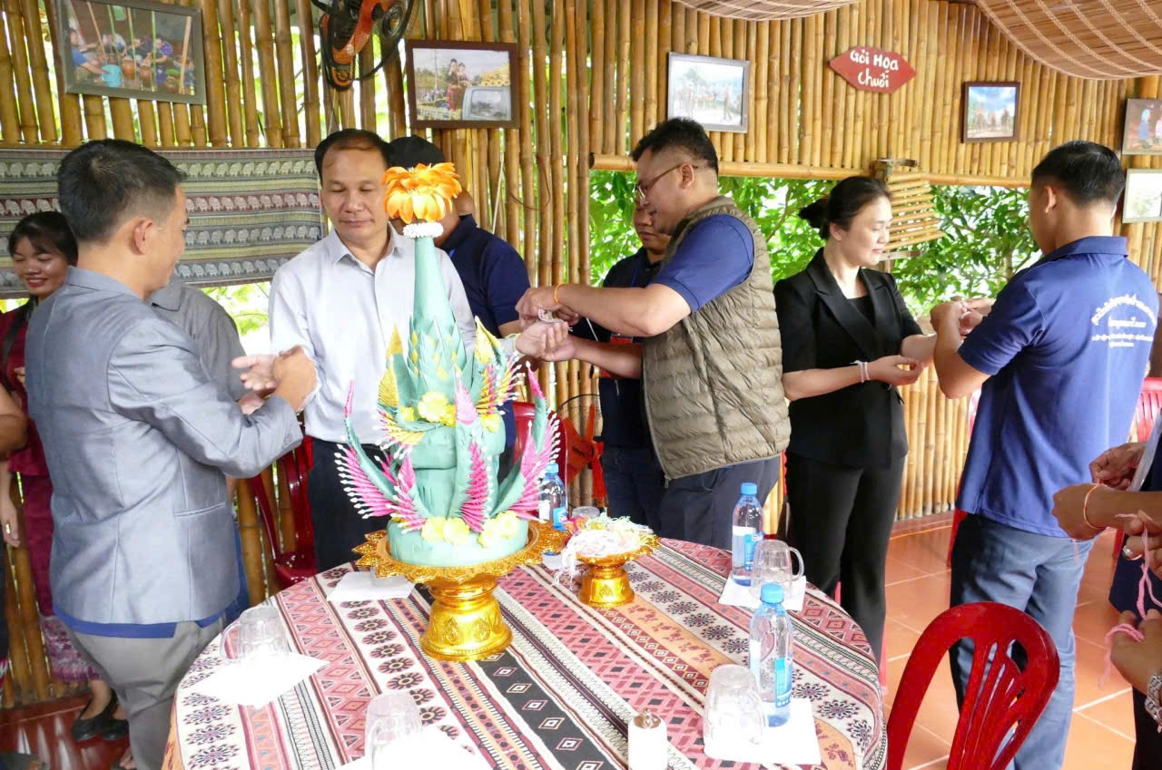 Người Lào ở xã Buôn Đôn (tỉnh Đắk Lắk) thực hiện nghi thức buộc chỉ cổ tay cho các thành viên trong đoàn công tác