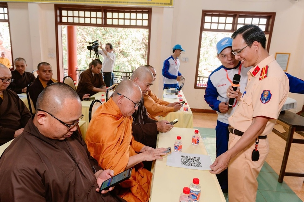 Chư tăng ni tham dự quét mã QR để tìm hiểu kiến thức pháp luật về giao thông
