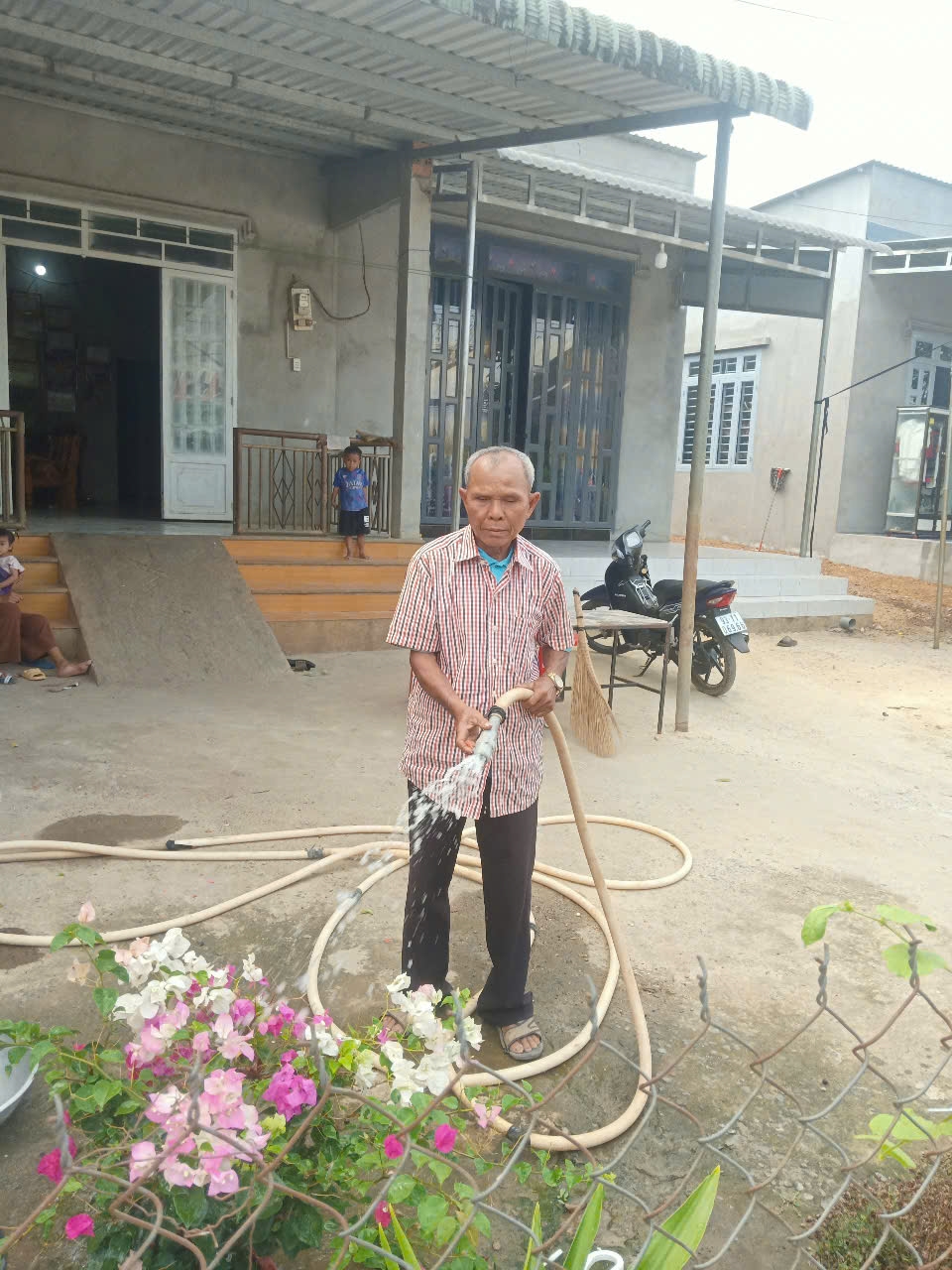 Già làng Điểu Cu chăm sóc cây cảnh trước nhà