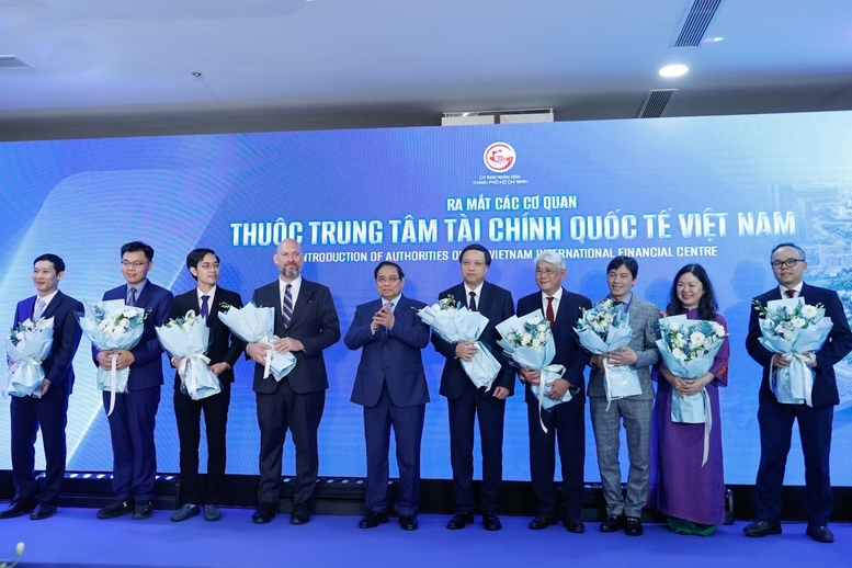 Thủ tướng Phạm Minh Chính tặng hoa cho đại diện các cơ quan thuộc Trung tâm Tài chính quốc tế Việt Nam - Ảnh: VGP/Nhật Bắc