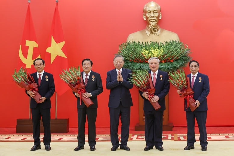 Tổng Bí thư Tô Lâm tặng hoa chúc mừng các đồng chí được nhận Huân chương Quân công hạng nhất - Ảnh: VGP/Nhật Bắc