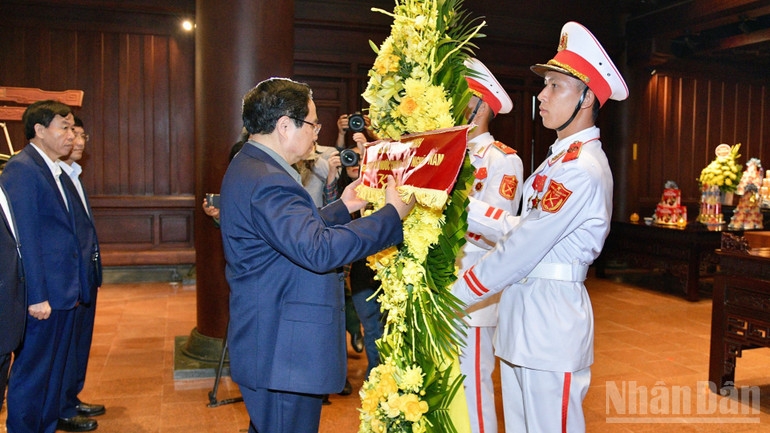 Thủ tướng Phạm Minh Chính chỉnh hoa trước khi thực hiện nghi lễ dâng hương, dâng hoa tưởng nhớ các Anh hùng liệt sĩ chiến trường Điện Biên Phủ. (Ảnh: THANH GIANG) 