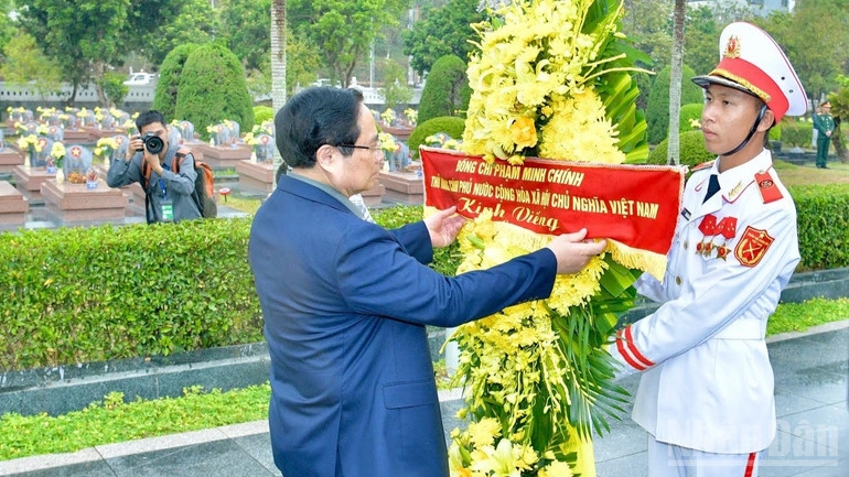 Thủ tướng Phạm Minh Chính chỉnh hoa trước khi thực hiện nghi lễ dâng hương, dâng hoa tưởng nhớ các Anh hùng liệt sĩ tại Nghĩa trang liệt sĩ quốc gia A1. (Ảnh: THANH GIANG)