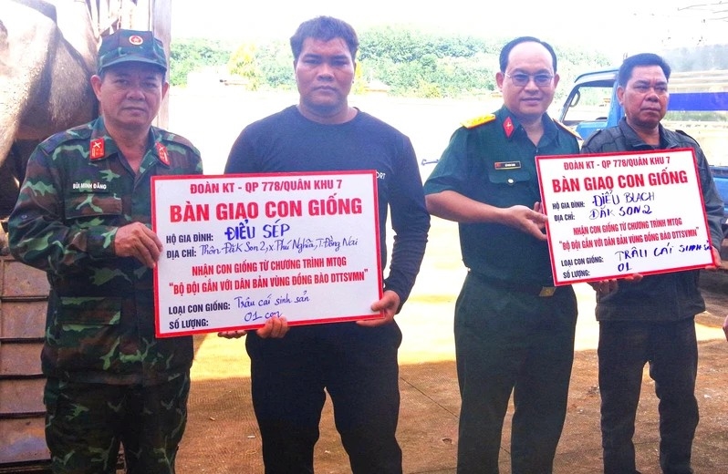 Đại tá Bùi Minh Đăng, Đoàn trưởng Đoàn KTQP 778 (ngoài cùng bên trái) tặng bò giống sinh sản cho các hộ gia đình tôn giáo khó khăn