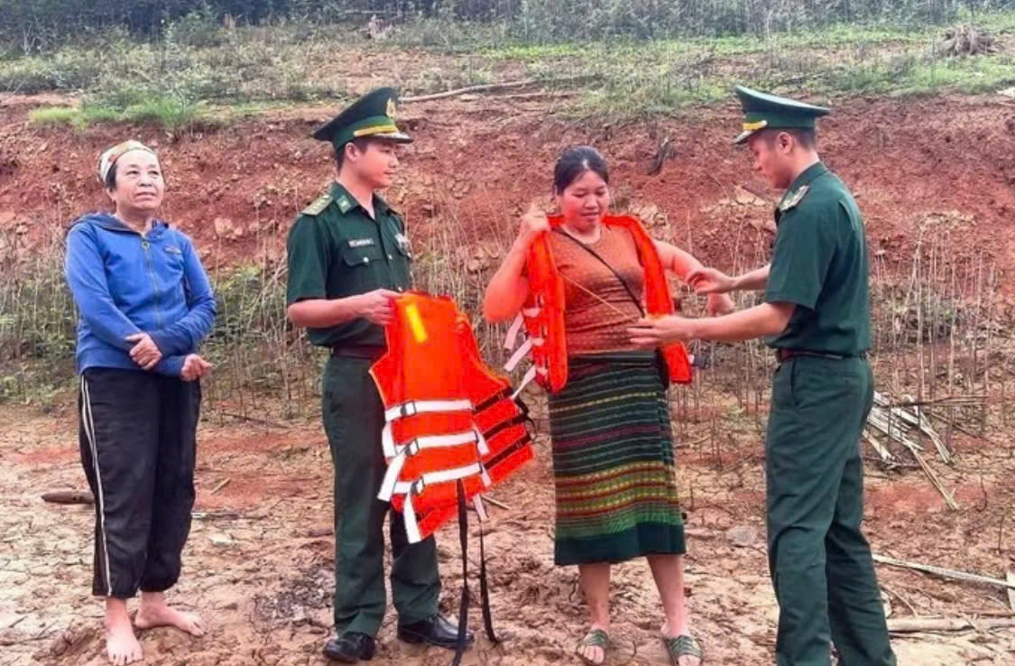 Cán bộ, chiến sĩ Đồn Biên phòng Thông Thụ trao tặng và hướng dẫn cách sử dụng áo phao đúng cách người dân sinh sống quanh khu vực lòng hồ Thủy điện Hủa Na; tuyên truyền nâng cao ý thức, thực hiện nghiêm việc đảm bảo an toàn giao thông đường thủy trên lòng hồ. Ảnh: TTXVN phát