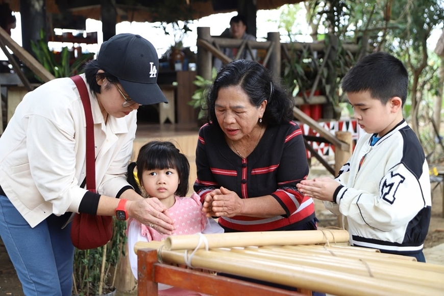 Nghệ nhân ưu tú Y Sinh chia sẻ câu chuyện về nguồn gốc và ý nghĩa của K'lông-pút, thu hút sự quan tâm của du khách. Ảnh: Hải Đăng