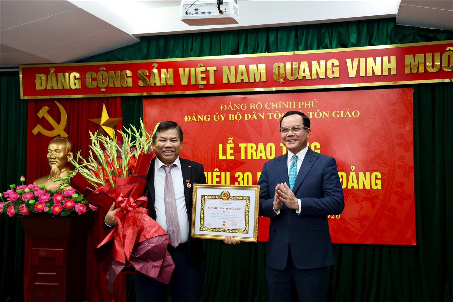 Đồng chí Nguyễn Đình Khang, Ủy viên Trung ương Đảng, Bí thư Đảng ủy, Bộ trưởng Bộ Dân tộc và Tôn giáo trao tặng Huy hiệu 30 năm tuổi Đảng cho Thứ trưởng Y Thông