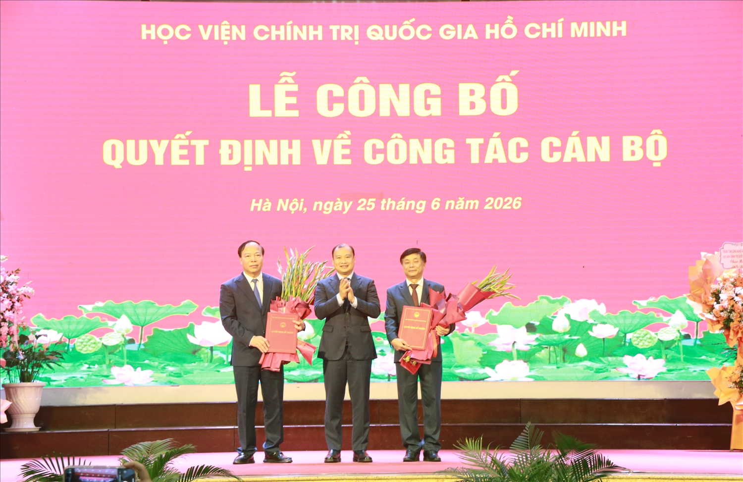 PGS.TS. Lê Hải Bình, Phó Giám đốc Thường trực Học viện Chính trị Quốc gia Hồ Chí Minh trao Quyết định bổ nhiệm lại chức danh Giám đốc Học viện Báo chí và Tuyên truyền đối với PGS.TS. Phạm Minh Sơn và Quyết định bổ nhiệm Phó Giám đốc Thường trực Học viện Báo chí và Tuyên truyền đối với PGS.TS. Mai Đức Ngọc, Bí thư Đảng ủy Học viện