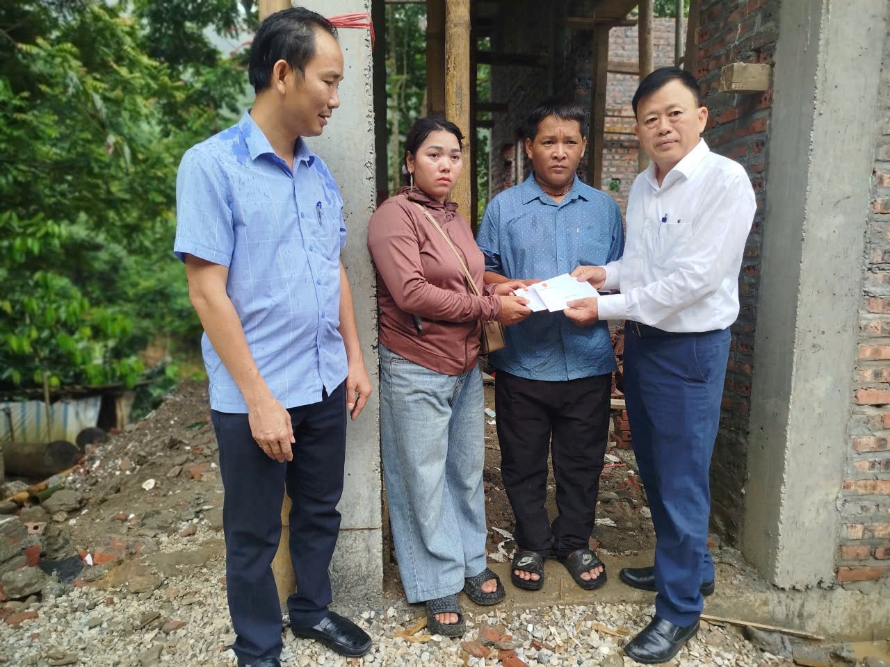 Ông Ma Thế Luận (ngoài cùng bên phải), Phó Vụ trưởng Vụ Tuyên truyền công tác dân tộc, tôn giáo đại diện Đoàn công tác trao quà cho gia đình bà Lò Thị Nguyệt. Ảnh: HBH