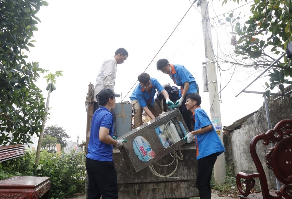 Thanh niên đồng lòng hỗ trợ người dân di dời tài sản đến nơi tạm cư. Ảnh: Bnews phát