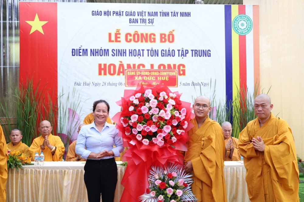 Lãnh đạo chính quyền xã Đức Huệ tặng hoa chúc mừng tại buổi lễ