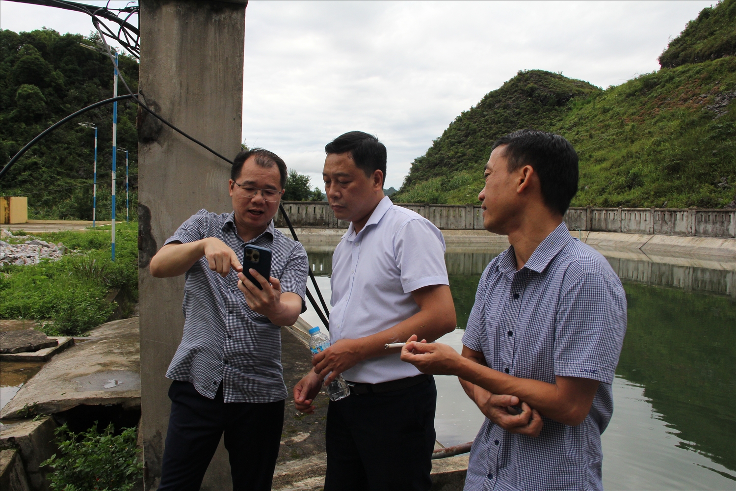 Ông Phùng Quốc Huy, Phó Chánh Văn phòng Quốc gia về dân tộc và miền núi, Bộ Dân tộc và Tôn giáo (áo trắng), trưởng đoàn kiểm tra liên ngành và ông Sèn Thăng Long, Phó Giám đốc Sở Dân tộc và Tôn giáo tỉnh Tuyên Quang trao đổi về bài toán tích trữ nước tại một hồ treo thuộc xã Mèo Vạc, tỉnh Tuyên Quang