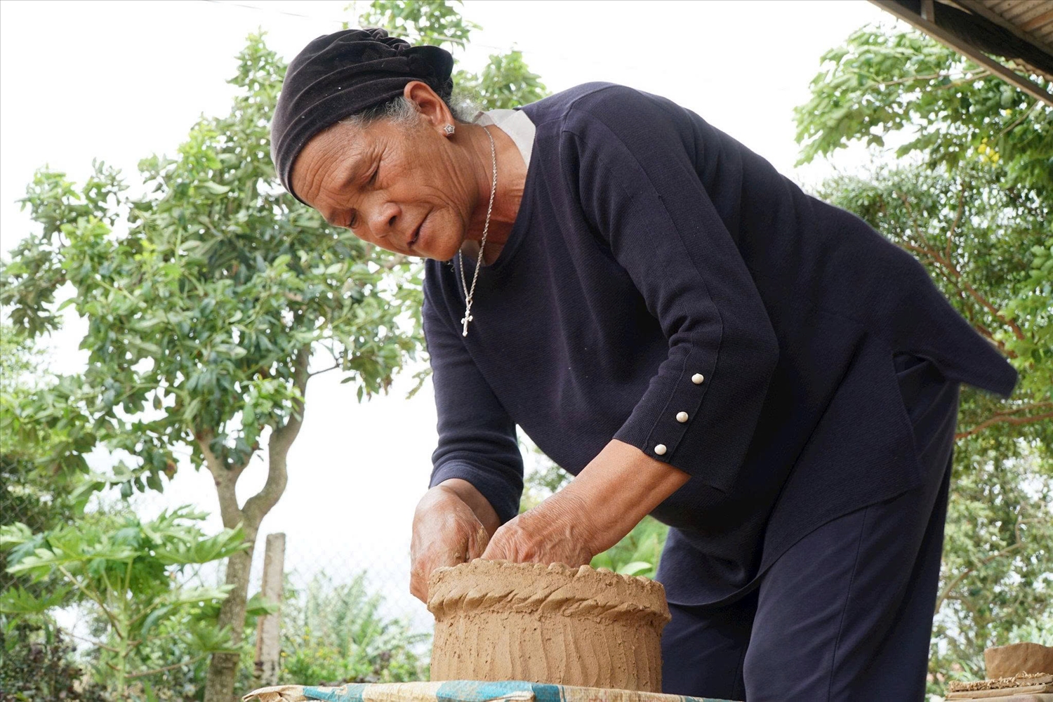 Bà Ma Ly cần mẫn tạo hình từng sản phẩm gốm thủ công, gìn giữ nghề gốm truyền thống của đồng bào Churu giữa buôn K'răng Gọ