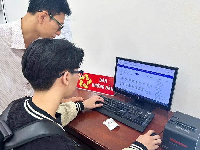 Cán bộ xã hướng dẫn người dân truy cập Cổng Pháp luật quốc gia. Ảnh minh họa