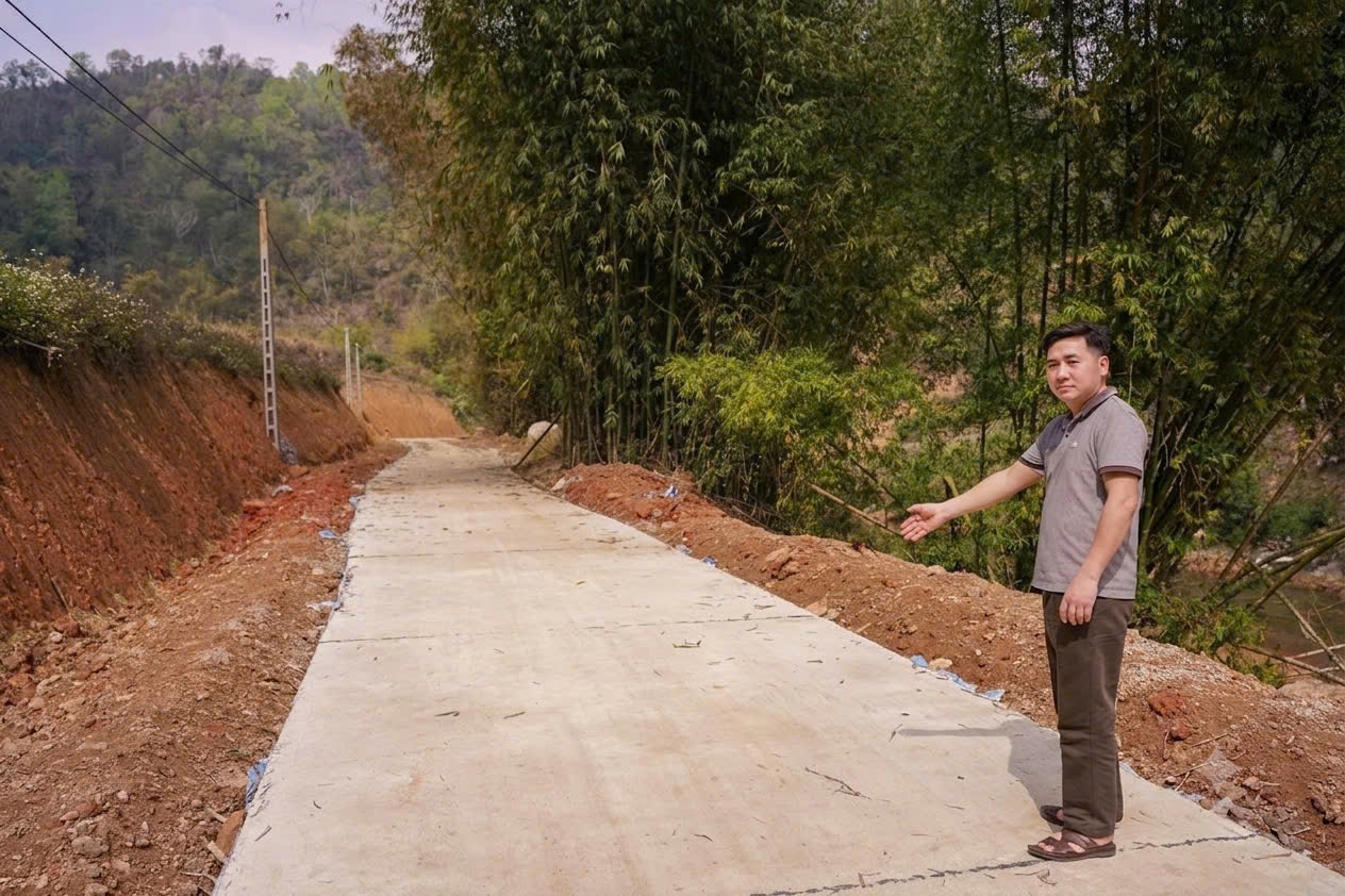 Anh Triệu Văn Hữu bên con đường bê tông kiên cố, được xây dựng trên diện tích đất của gia đình và bà con thônKhun Pàu tự nguyện hiến tặng