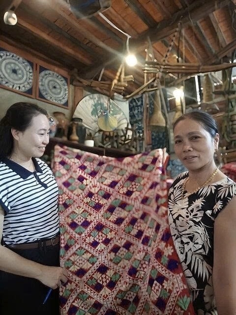 Bà Vì Thị Xoan giới thiệu tấm vải truyền thống với hoa văn quả trám, một nét đặc trưng trong nghệ thuật dệt thổ cẩm của người Thái