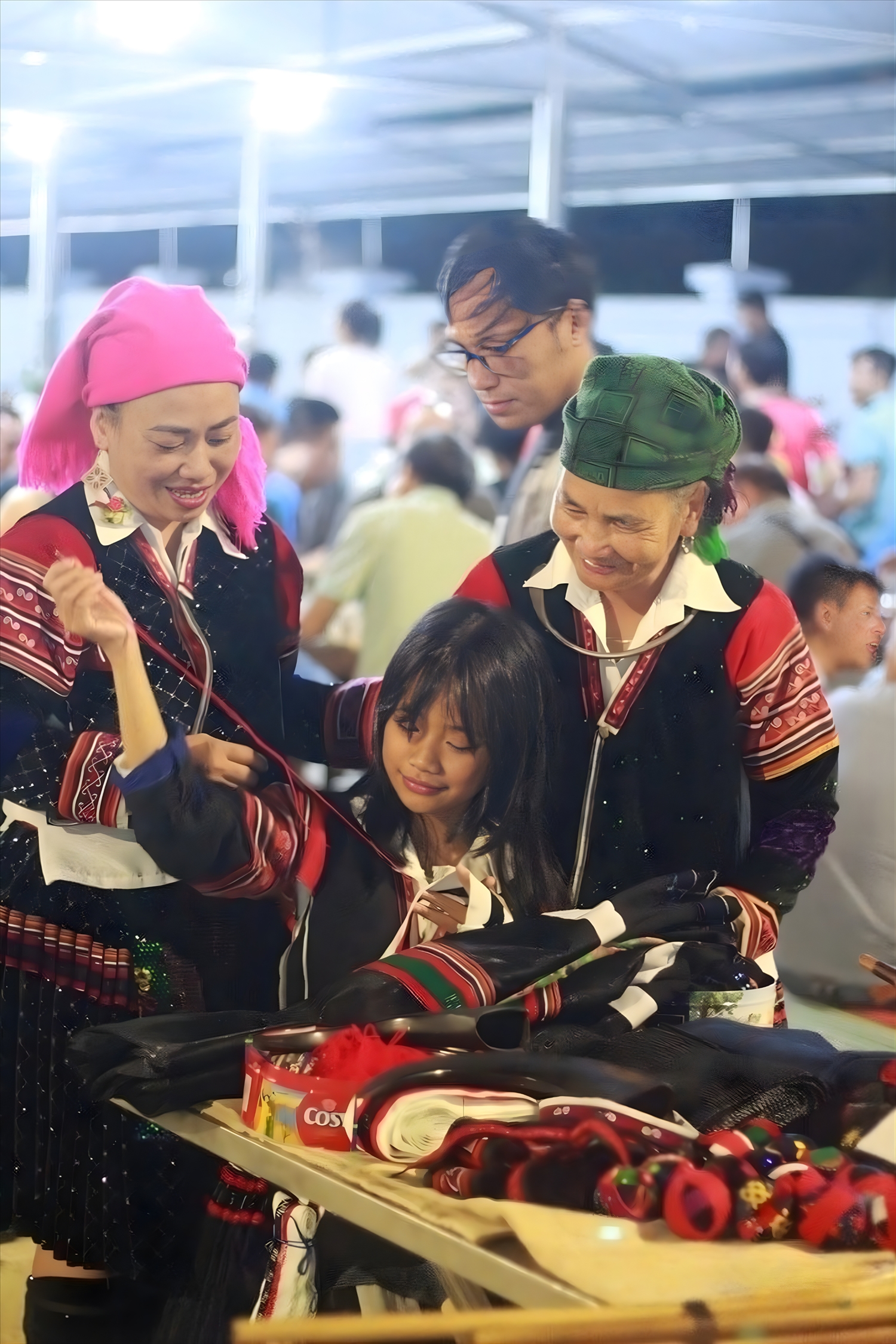 A mother teaches her daughter how to embroider patterns and motifs onto traditional brocade