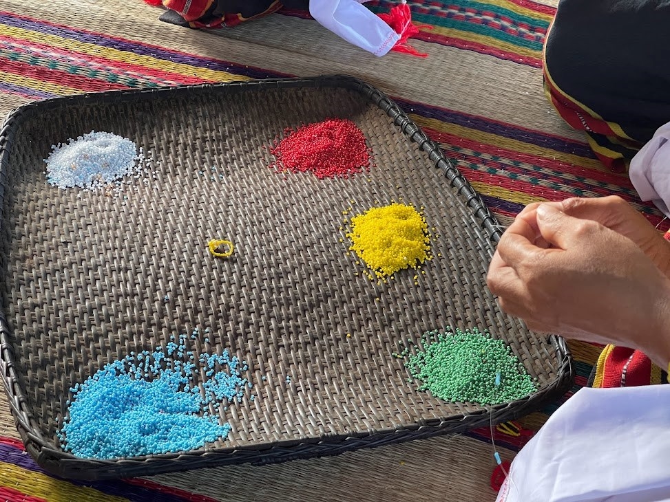 Co women string colorful beads together to create unique jewelry sets