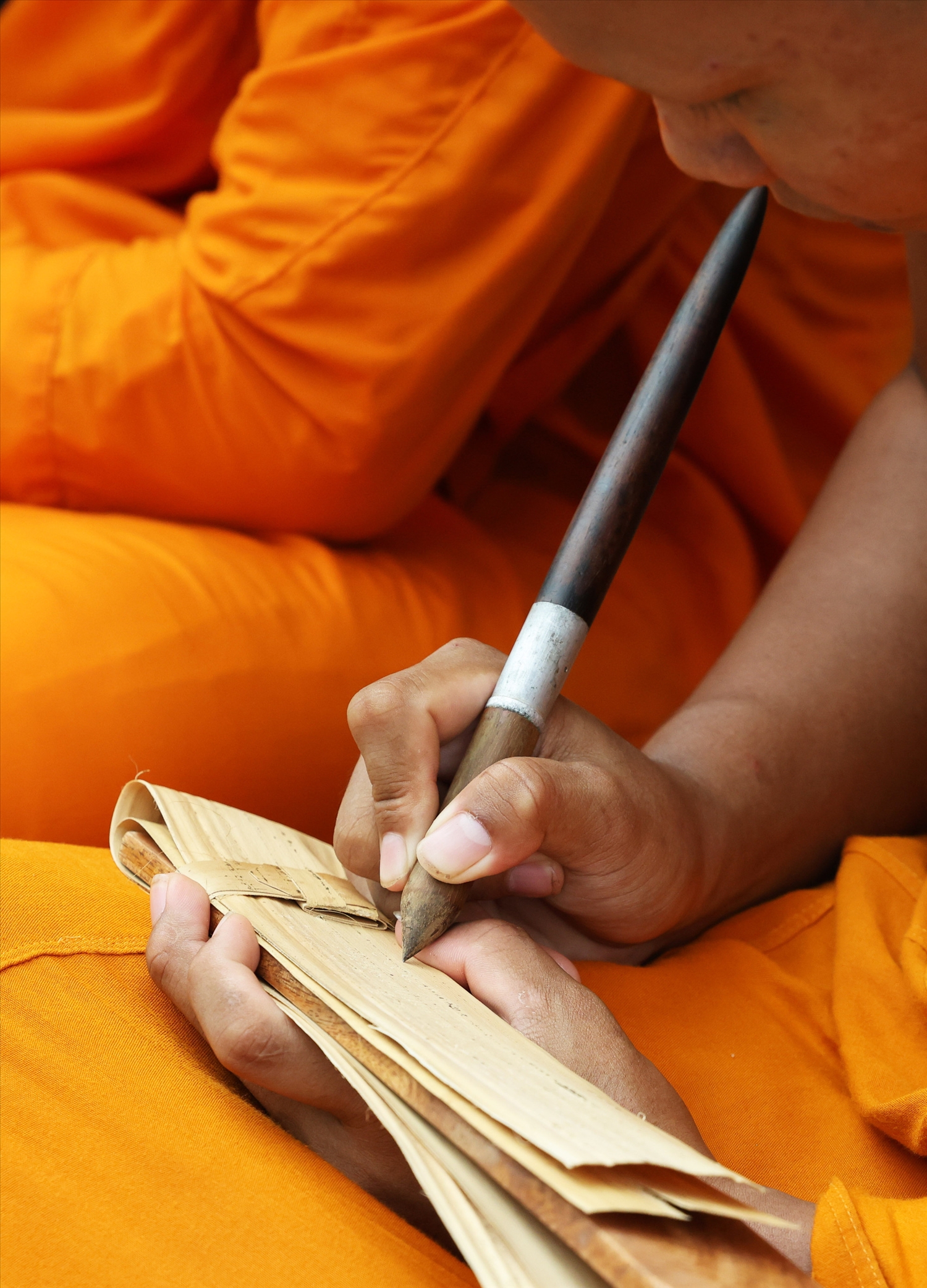 The monks are writing on palm-leaf manuscripts 