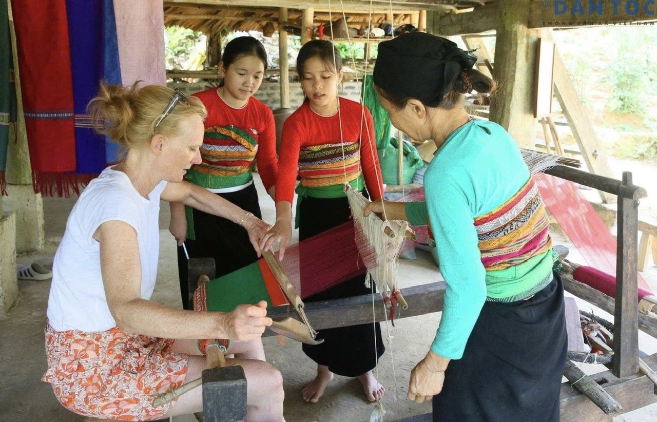 Du khách nước ngoài tập làm nghề dệt thổ cẩm