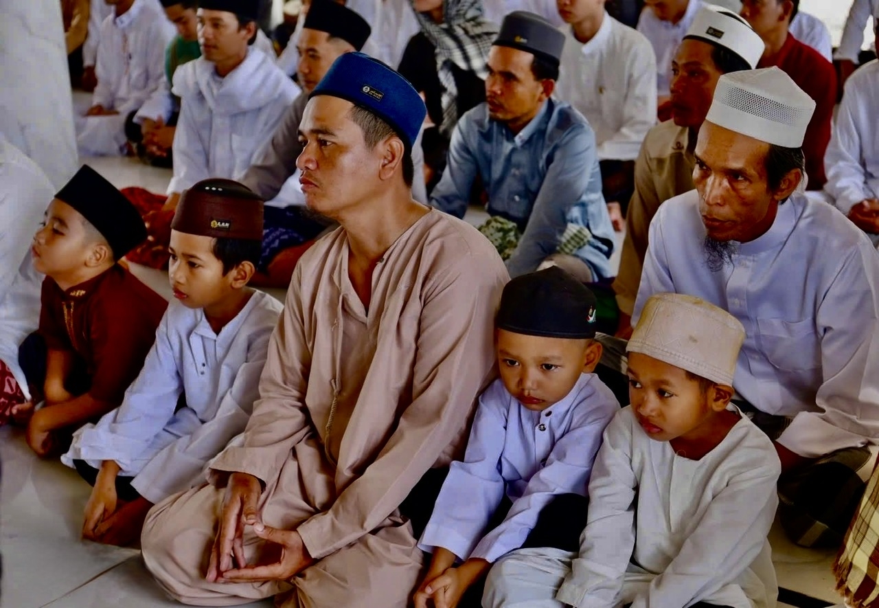 Trẻ em Chăm được cha đưa đến thánh đường tham gia sinh hoạt tín ngưỡng, qua đó từng bước tiếp nhận và gìn giữ những giá trị văn hóa của cộng đồng