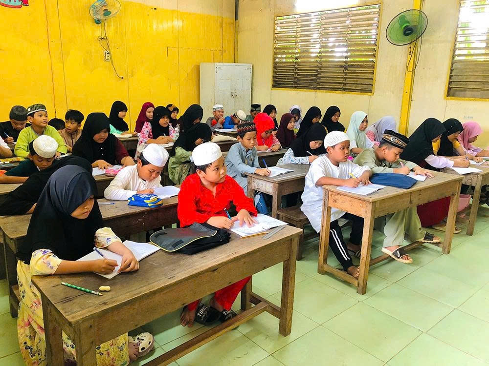 Học sinh dân tộc Chăm ở xã Tây Yên (An Giang) chăm chú lắng nghe lời giảng của giáo viên trong lớp học tiếng Chăm, góp phần gìn giữ tiếng nói, chữ viết và bản sắc văn hóa dân tộc