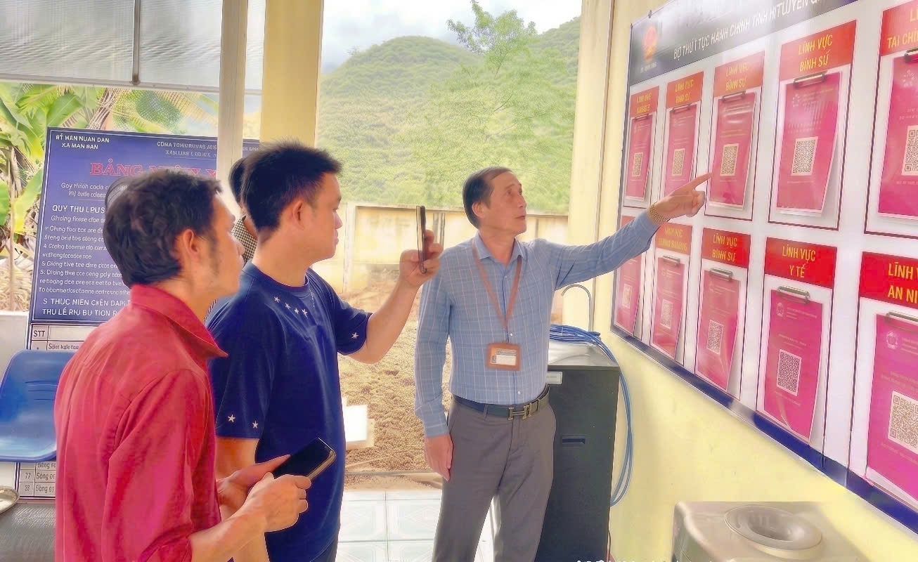 Cán bộ Trung tâm Phục vụ hành chính công xã Mậu Duệ hướng dẫn người dân quét mã QR để tra cứu và thực hiện thủ tục hành chính trực tuyến.