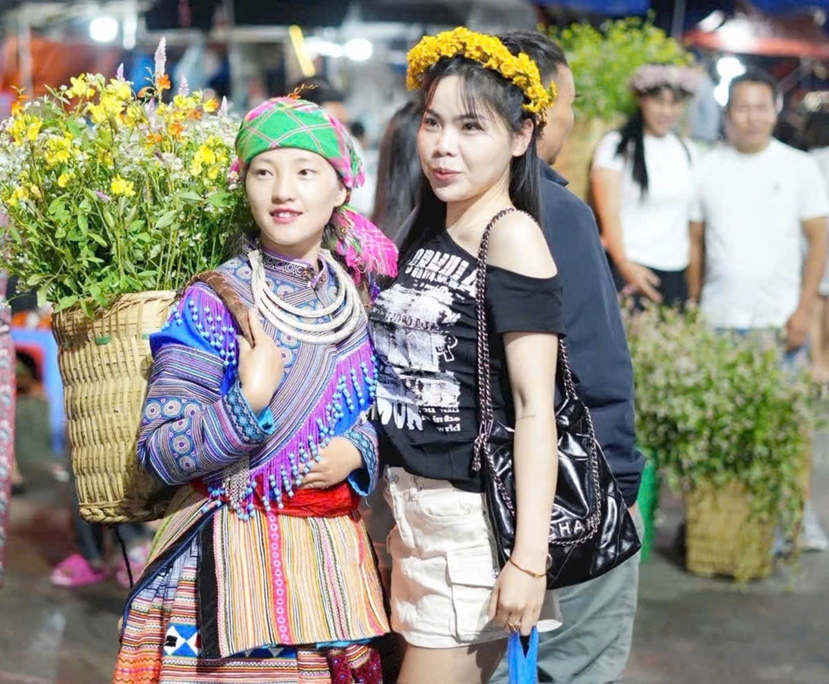 Du khách thích thú giao lưu và chụp ảnh cùng các thiếu nữ dân tộc thiểu số tại chợ văn hóa xã Bắc Hà (tỉnh Lào Cai)