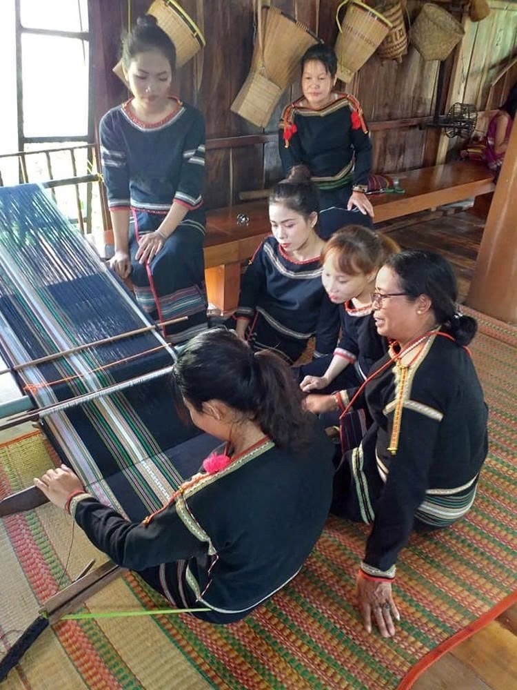 Bà H’Yam tận tình chia sẻ kinh nghiệm cho các thành viên cho các hội viên buôn Tơng Jŭ dệt thổ cẩm trên khung cửi truyền thống