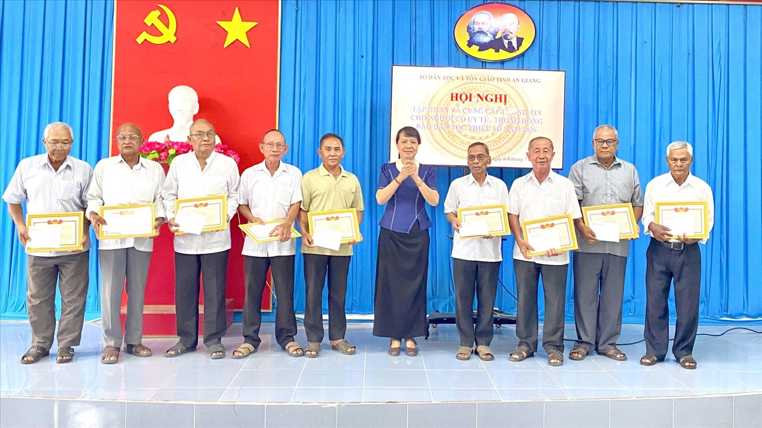 Ông Chau Văn Ni (bìa phải) nhận giấy khen của Giám đốc Sở Dân tộc và Tôn giáo về thành tích phát huy vai trò của Người có uy tín trong đồng bào dân tộc thiểu số năm 2026.