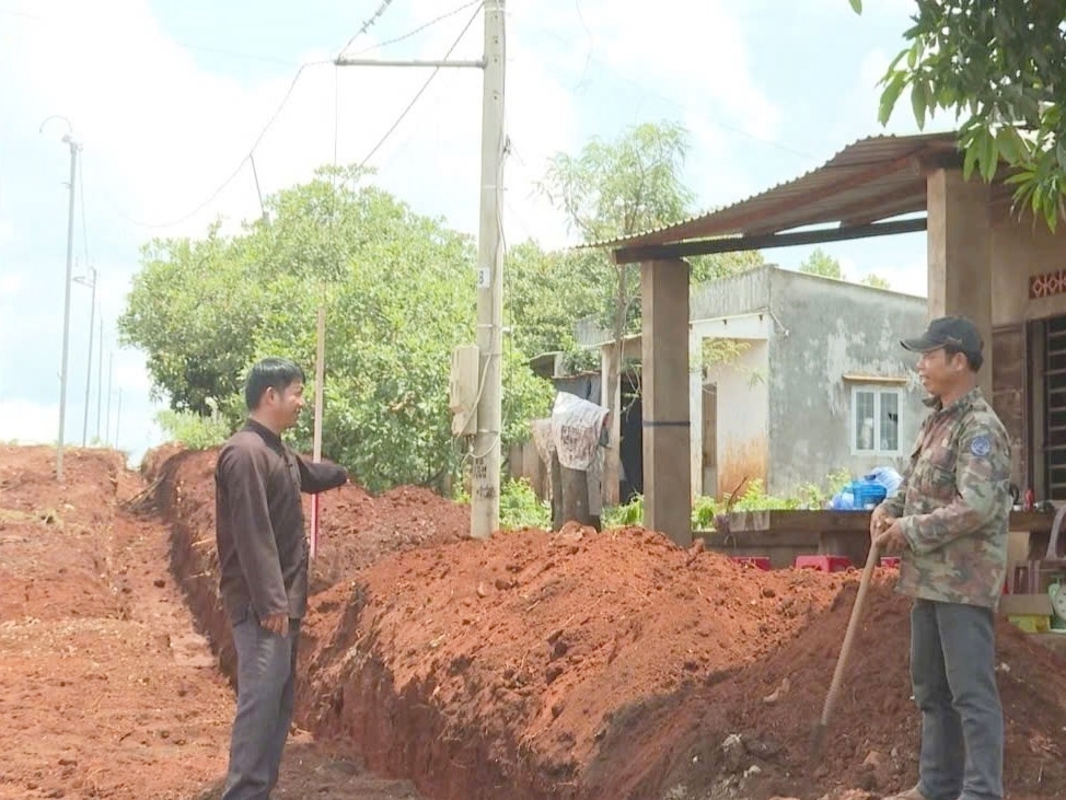 Người có uy tín Khằm Thanh Sơn (bên trái) vận động người dân xây dựng nông thôn mới.