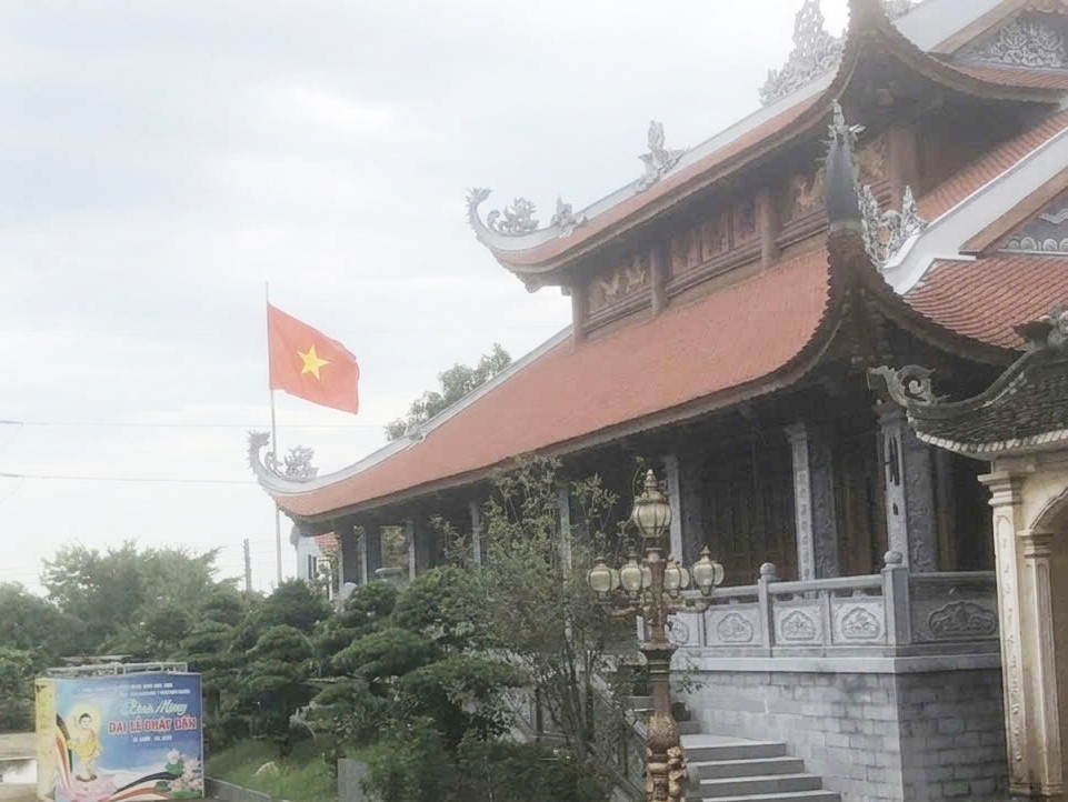 Sắc đỏ Quốc kỳ ngợp trời không chỉ tô điểm cho không gian thanh tịnh nơi thờ tự nhân lên niềm tự hào dân tộc