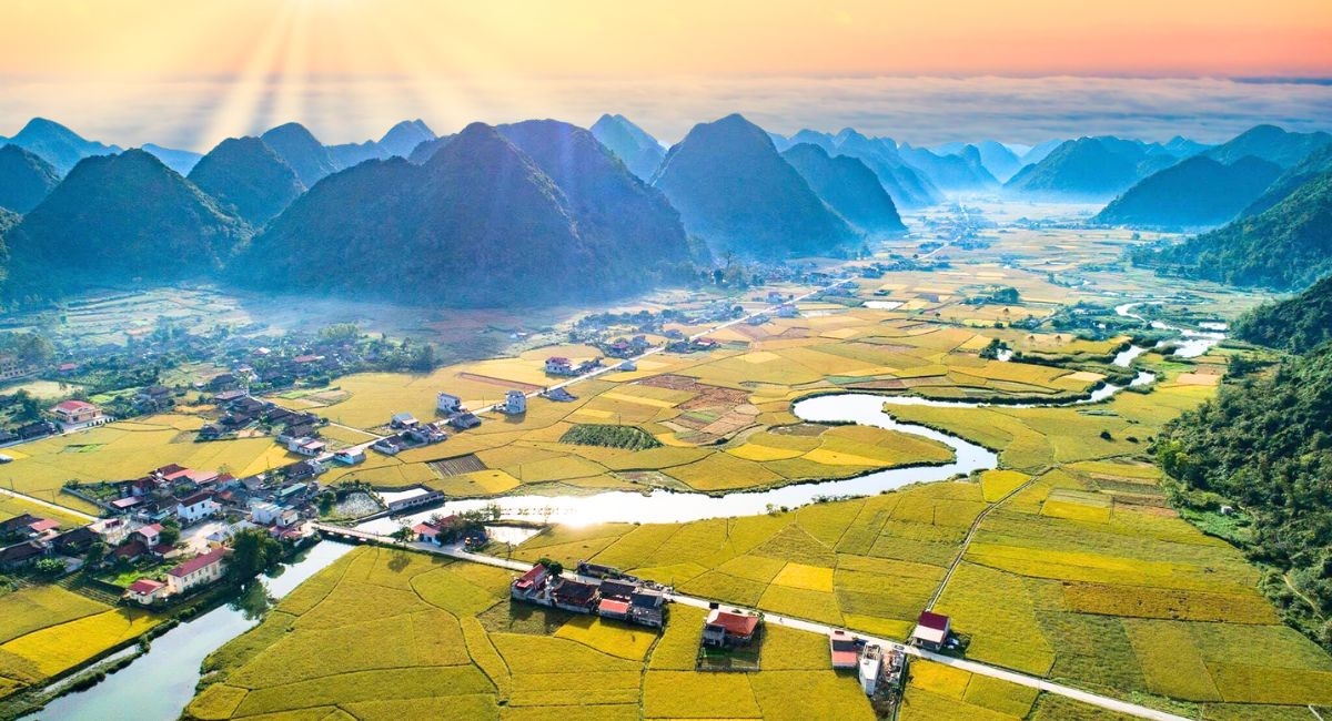 Từ đỉnh, thung lũng Bắc Sơn mở ra dưới tầm mắt như bức tranh lúa vàng óng ả, những con đường uốn lượn mềm mại như dải lụa giữa làn sương. Bình minh nơi đây là giấc mơ của những tay săn ảnh, khi mây vờn qua nóc nhà sàn, ánh nắng đầu ngày rót mật xuống từng vạt ruộng